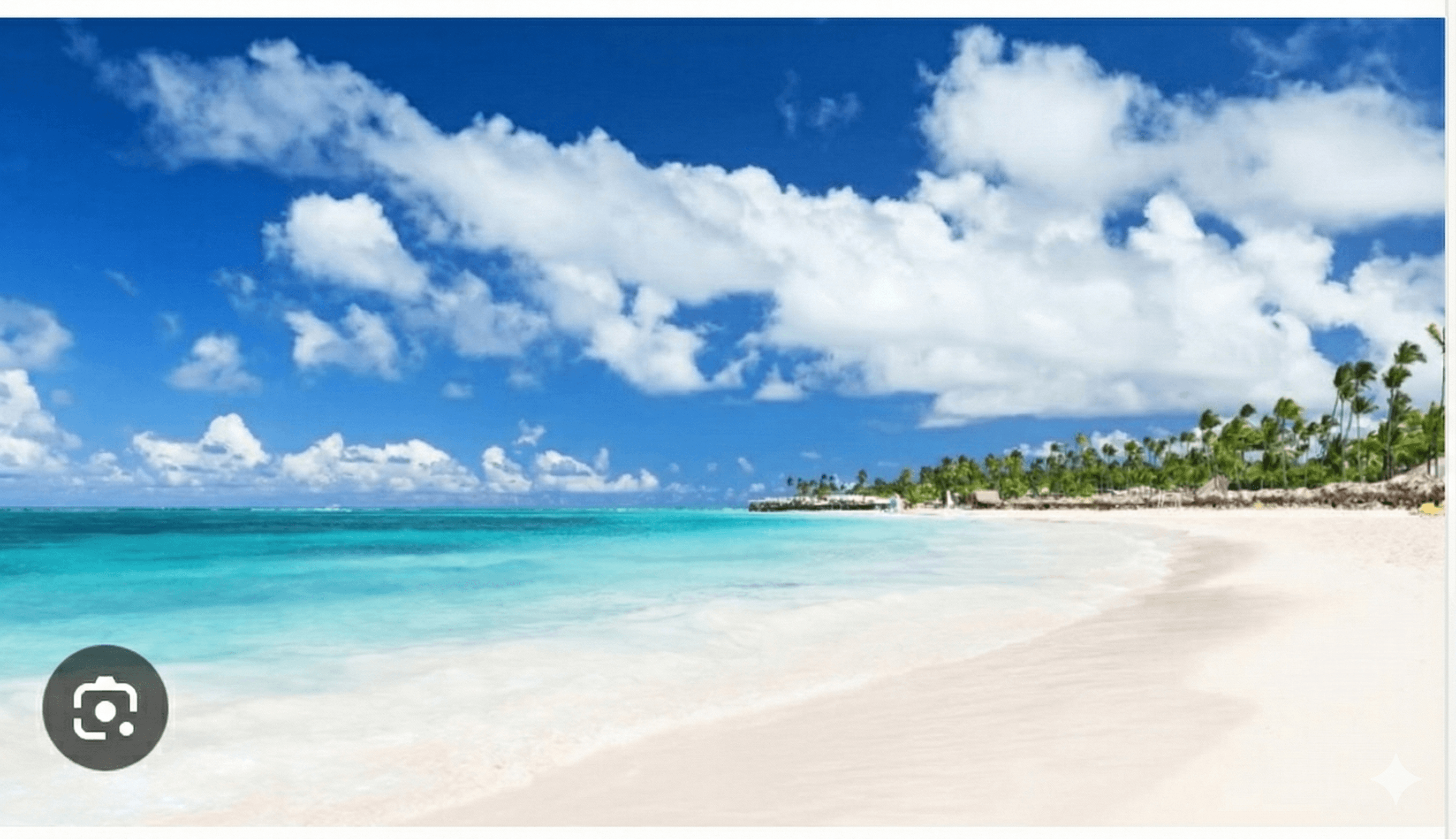 Sunbeds under a palm leaf umbrella on the beach